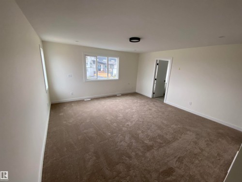 Empty room with carpet flooring and baseboards - 5421 60 Avenue, Vegreville, AB - Indoor Photo Showing Other Room