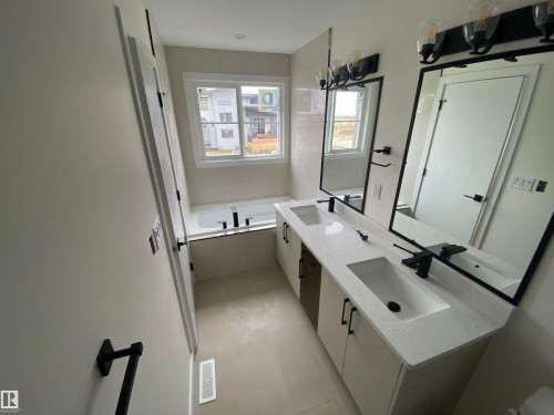 Bathroom with double vanity, a bath, and light tile patterned flooring - 5421 60 Avenue, Vegreville, AB - Indoor
