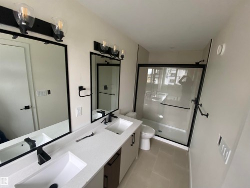 Bathroom with double vanity, a stall shower, and light tile patterned floors - 5421 60 Avenue, Vegreville, AB - Indoor