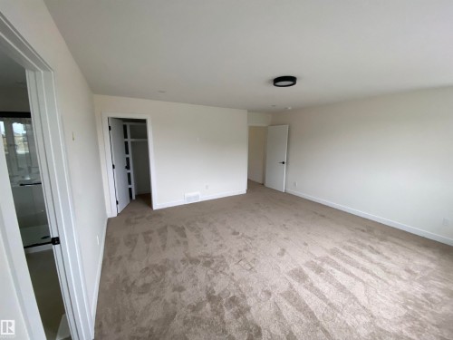 Unfurnished bedroom with a spacious closet and light carpet - 5421 60 Avenue, Vegreville, AB - Indoor Photo Showing Other Room