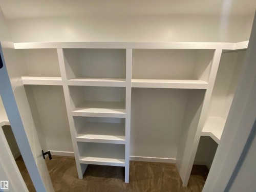 Walk in closet with dark colored carpet - 5421 60 Avenue, Vegreville, AB - Indoor With Storage
