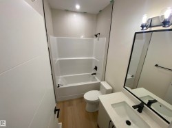 Bathroom featuring vanity, light wood-style floors, and washtub / shower combination - 