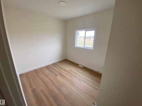 Spare room featuring light wood-style floors and baseboards - 5421 60 Avenue, Vegreville, AB - Indoor Photo Showing Other Room