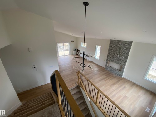 Staircase featuring wood finished floors and lofted ceiling - 5421 60 Avenue, Vegreville, AB - Indoor Photo Showing Other Room