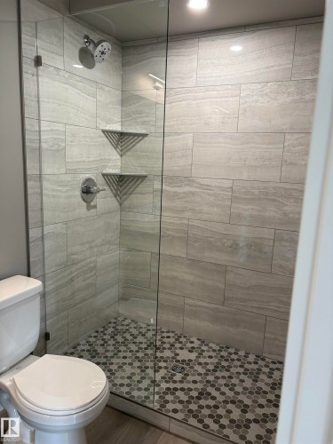 Bathroom featuring a shower stall and wood finished floors - 7413 44 Avenue, Camrose, AB - Indoor Photo Showing Bathroom