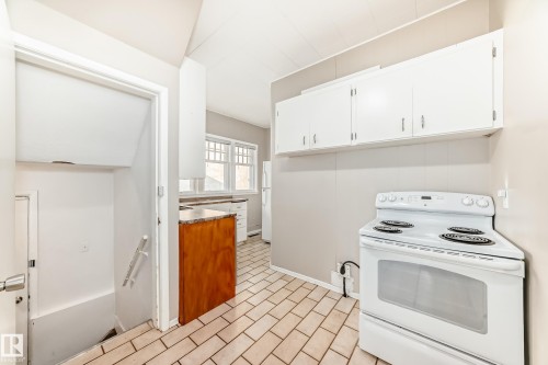 Kitchen featuring white appliances, white cabinets, and light tile patterned flooring - 12605 107 Avenue, Edmonton, AB - Indoor Photo Showing Kitchen