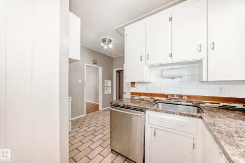 Kitchen with dishwasher, decorative backsplash, white cabinetry, and light countertops - 12605 107 Avenue, Edmonton, AB - Indoor Photo Showing Kitchen
