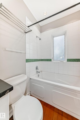Full bathroom featuring bathing tub / shower combination, wood finished floors, and vanity - 12605 107 Avenue, Edmonton, AB - Indoor Photo Showing Bathroom