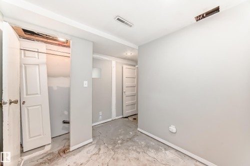 Unfurnished bedroom featuring baseboards and concrete flooring - 12605 107 Avenue, Edmonton, AB - Indoor Photo Showing Other Room