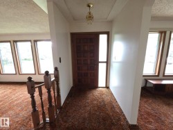 Carpeted entrance foyer with a textured ceiling - 