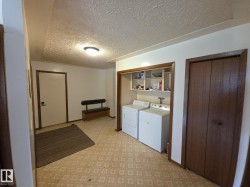 Laundry area with a textured ceiling and washer and clothes dryer - 