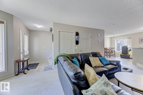 Living area with a textured ceiling and light carpet - 18 5281 Terwillegar Boulevard, Edmonton, AB - Indoor Photo Showing Living Room