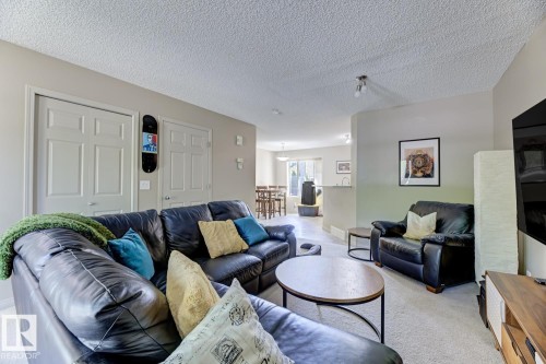 Carpeted living room with a textured ceiling - 18 5281 Terwillegar Boulevard, Edmonton, AB - Indoor Photo Showing Living Room