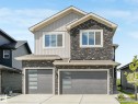 View of front of house with stone siding, an attached garage, driveway, and board and batten siding - 15 Elwyck Gate, Spruce Grove, AB  - Outdoor 