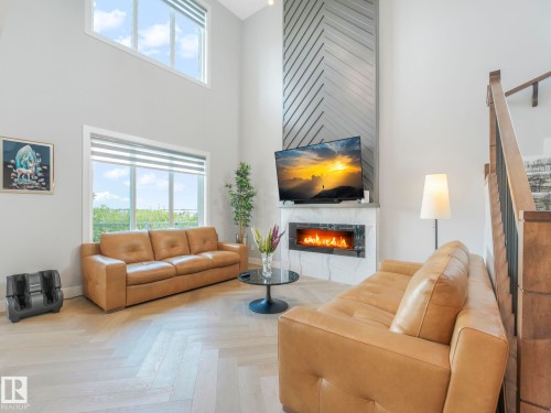 Living area with a high ceiling, healthy amount of natural light, and a fireplace - 15 Elwyck Gate, Spruce Grove, AB - Indoor Photo Showing Living Room With Fireplace