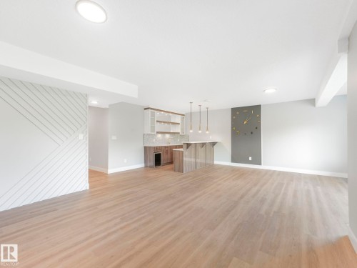 Unfurnished living room with light wood-style floors, wet bar, and wine cooler - 15 Elwyck Gate, Spruce Grove, AB - Indoor
