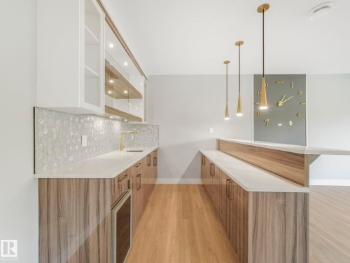 Indoor wet bar with light wood finished floors, tasteful backsplash, pendant lighting, and recessed lighting - 15 Elwyck Gate, Spruce Grove, AB - Indoor