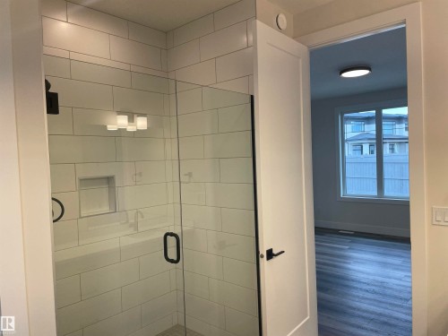 Bathroom featuring a stall shower and wood finished floors - 4112 Ginsburg Place, Edmonton, AB - Indoor Photo Showing Bathroom