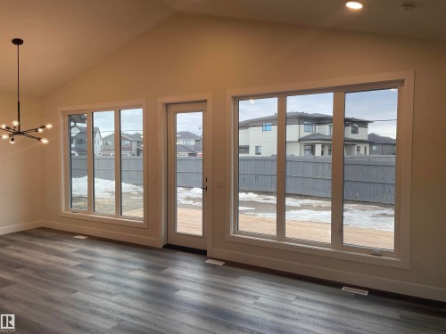 Interior space featuring a residential view, hanging lights, and dark wood finished floors - 4112 Ginsburg Place, Edmonton, AB - Indoor Photo Showing Other Room