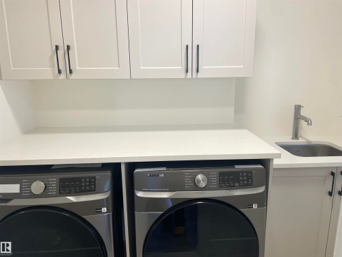 Laundry room featuring cabinet space and washing machine and clothes dryer - 4112 Ginsburg Place, Edmonton, AB - Indoor Photo Showing Laundry Room