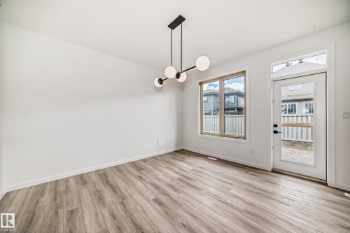 Unfurnished dining area featuring light wood-type flooring and a chandelier - 1401 Ainslie Wynd, Edmonton, AB - Indoor Photo Showing Other Room