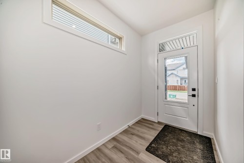 Doorway featuring baseboards and light wood finished floors - 1401 Ainslie Wynd, Edmonton, AB - Indoor Photo Showing Other Room