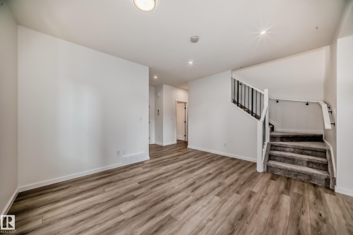 Unfurnished living room featuring stairway, wood finished floors, and recessed lighting - 1401 Ainslie Wynd, Edmonton, AB - Indoor Photo Showing Other Room