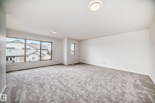 Spare room with plenty of natural light and carpet - 1401 Ainslie Wynd, Edmonton, AB - Indoor Photo Showing Other Room