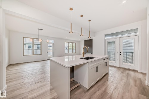 Kitchen featuring plenty of natural light, pendant lighting, light wood-style floors, and recessed lighting - 1401 Ainslie Wynd, Edmonton, AB - Indoor Photo Showing Kitchen With Upgraded Kitchen