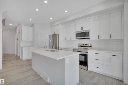 Kitchen featuring stainless steel appliances, a kitchen island with sink, white cabinetry, decorative backsplash, and recessed lighting - 2275 Alces Drive, Edmonton, AB - Indoor Photo Showing Kitchen With Upgraded Kitchen