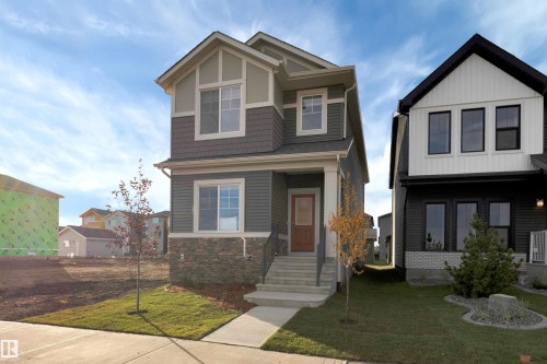 Craftsman-style home featuring a front yard and stone siding - 2275 Alces Drive, Edmonton, AB - Outdoor With Facade
