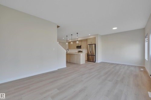 Unfurnished living room featuring recessed lighting and light wood-type flooring - 9104 Elves Loop, Edmonton, AB - Indoor Photo Showing Kitchen