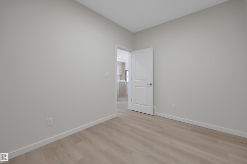 Spare room featuring baseboards and light wood finished floors - 9104 Elves Loop, Edmonton, AB - Indoor Photo Showing Other Room