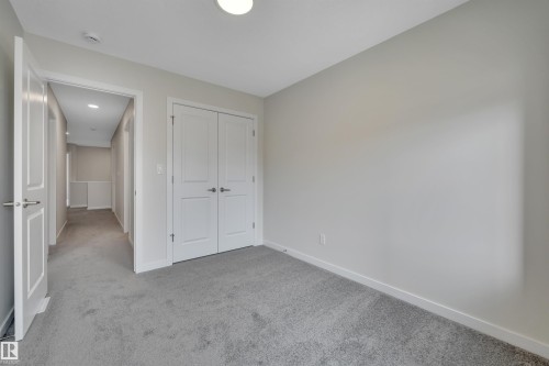 Unfurnished bedroom featuring light carpet and a closet - 9104 Elves Loop, Edmonton, AB - Indoor Photo Showing Other Room