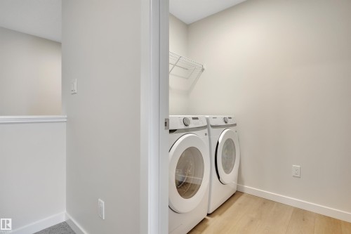 Washroom with independent washer and dryer and light wood-style floors - 9104 Elves Loop, Edmonton, AB - Indoor Photo Showing Laundry Room