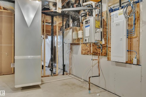 Utilities featuring tankless water heater and electric panel - 9104 Elves Loop, Edmonton, AB - Indoor Photo Showing Basement