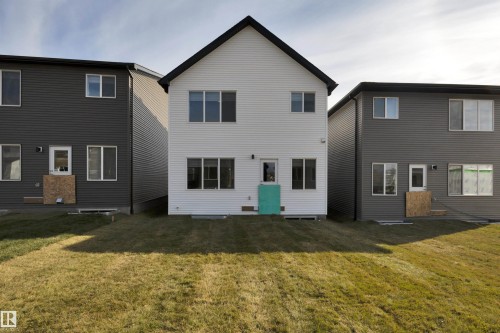 Rear view of property featuring a lawn - 9104 Elves Loop, Edmonton, AB - Outdoor