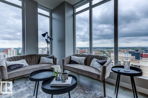 Living area featuring a city view, wood finished floors, and expansive windows - 9922 111 Street, Edmonton, AB - Indoor Photo Showing Living Room