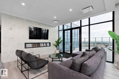 Living room featuring expansive windows, recessed lighting, light wood-style floors, a drop ceiling, and a fireplace - 9922 111 Street, Edmonton, AB - Indoor