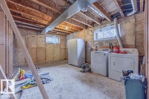 Below grade area separate washer and dryer, and healthy amount of natural light.  Stand up freezer not included. - 5026 53 Ave, Ryley, AB - Indoor Photo Showing Laundry Room