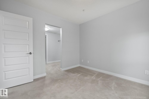 Empty room with carpet floors and baseboards - 810 5151 Windermere Boulevard, Edmonton, AB - Indoor Photo Showing Other Room