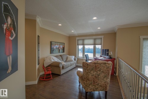 Living area with dark wood-style floors, ornamental molding, a textured ceiling, recessed lighting, and a desk - 5753 43 Ave, St. Paul Town, AB - Indoor