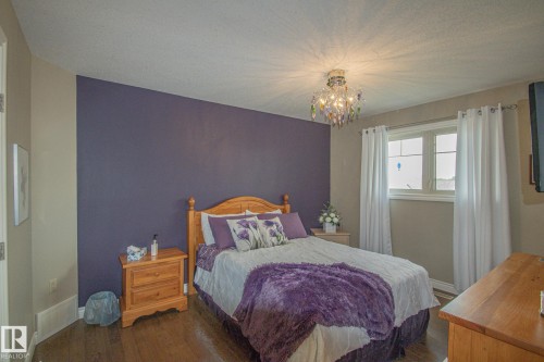 Bedroom featuring wood finished floors, a chandelier, and a textured ceiling - 5753 43 Ave, St. Paul Town, AB - Indoor Photo Showing Bedroom