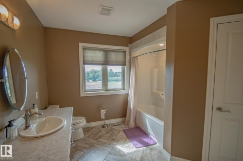 Full bathroom featuring vanity and shower / tub combo with curtain - 5753 43 Ave, St. Paul Town, AB - Indoor Photo Showing Bathroom