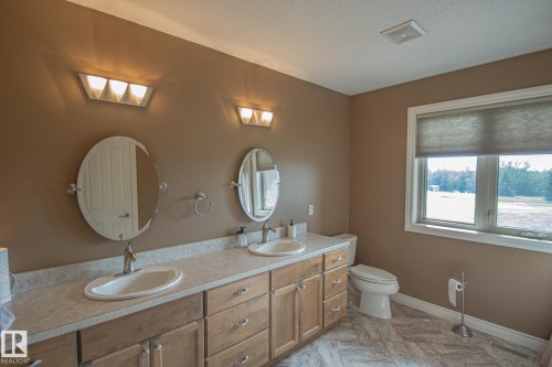 Bathroom with double vanity and baseboards - 5753 43 Ave, St. Paul Town, AB - Indoor Photo Showing Bathroom