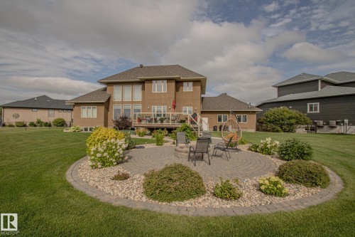 Back of house with a wooden deck, a yard, a patio, and a shingled roof - 5753 43 Ave, St. Paul Town, AB - Outdoor With Deck Patio Veranda
