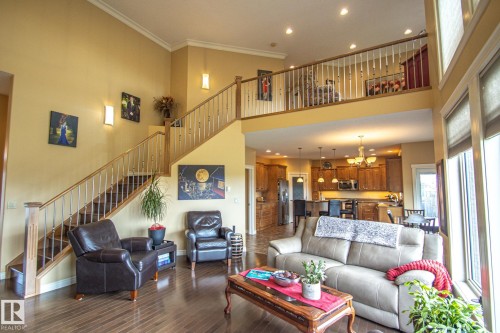 Living room featuring recessed lighting, stairway, a high ceiling, dark wood finished floors, and crown molding - 5753 43 Ave, St. Paul Town, AB - Indoor Photo Showing Living Room