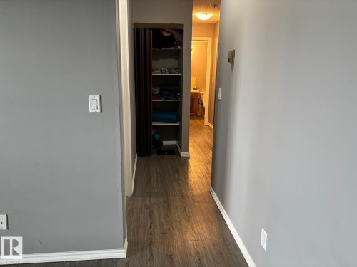 Hallway featuring dark wood-style floors - 209 5705 51 Street, Elk Point, AB - Indoor Photo Showing Other Room