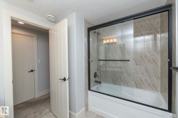 Full bathroom with shower / bath combination with glass door and a textured ceiling - 