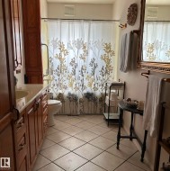 Bathroom with a textured ceiling, tile patterned floors, and vanity - 